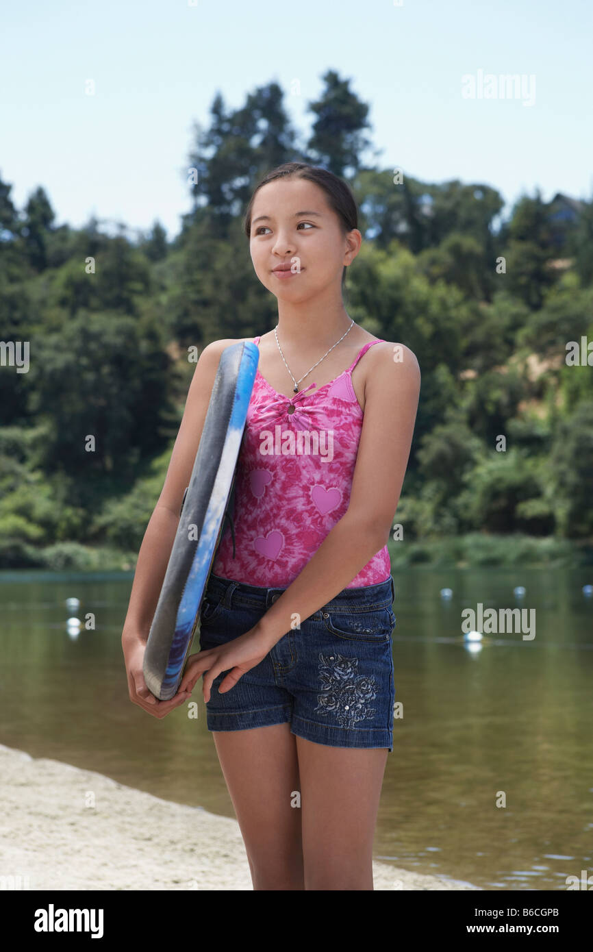 Mixed Race Girl Holding Boogie Board Near Lake Stock Photo Alamy