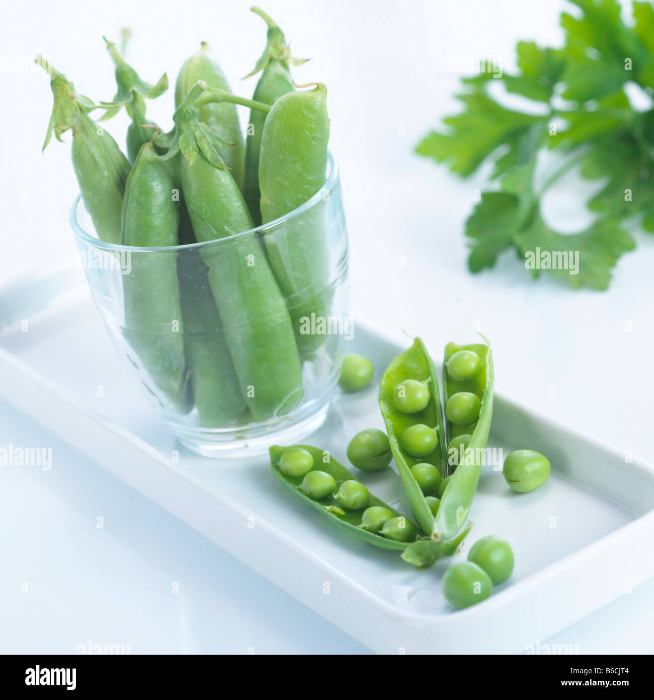 Close-up of pea pods and peas on tray Stock Photo