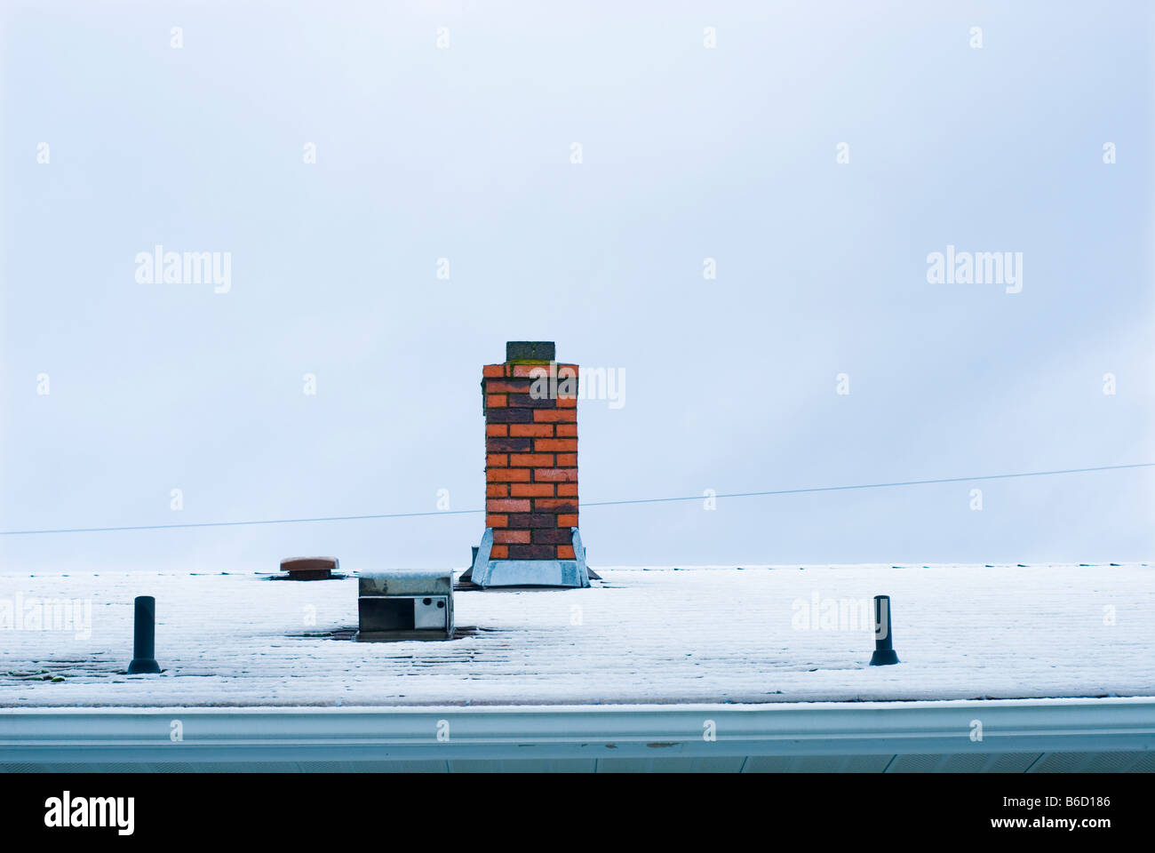 Chimney on a snow covered roof Stock Photo