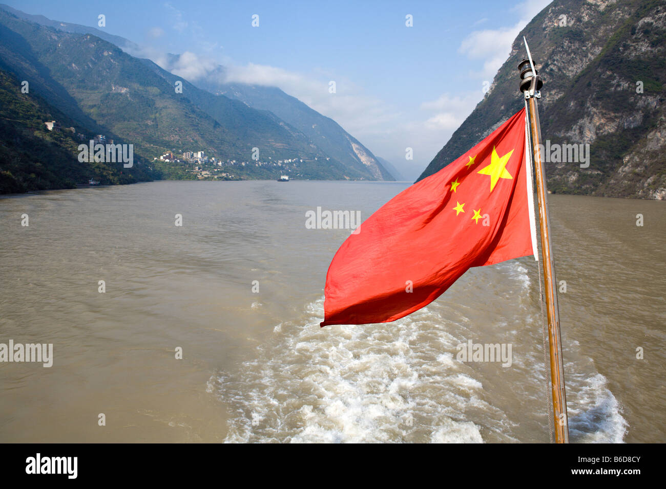 CHINA, YANGTZE RIVER GORGE: Bright red five starred flag of the Peoples Republic of China flies from a Yangtze River cruise ship Stock Photo