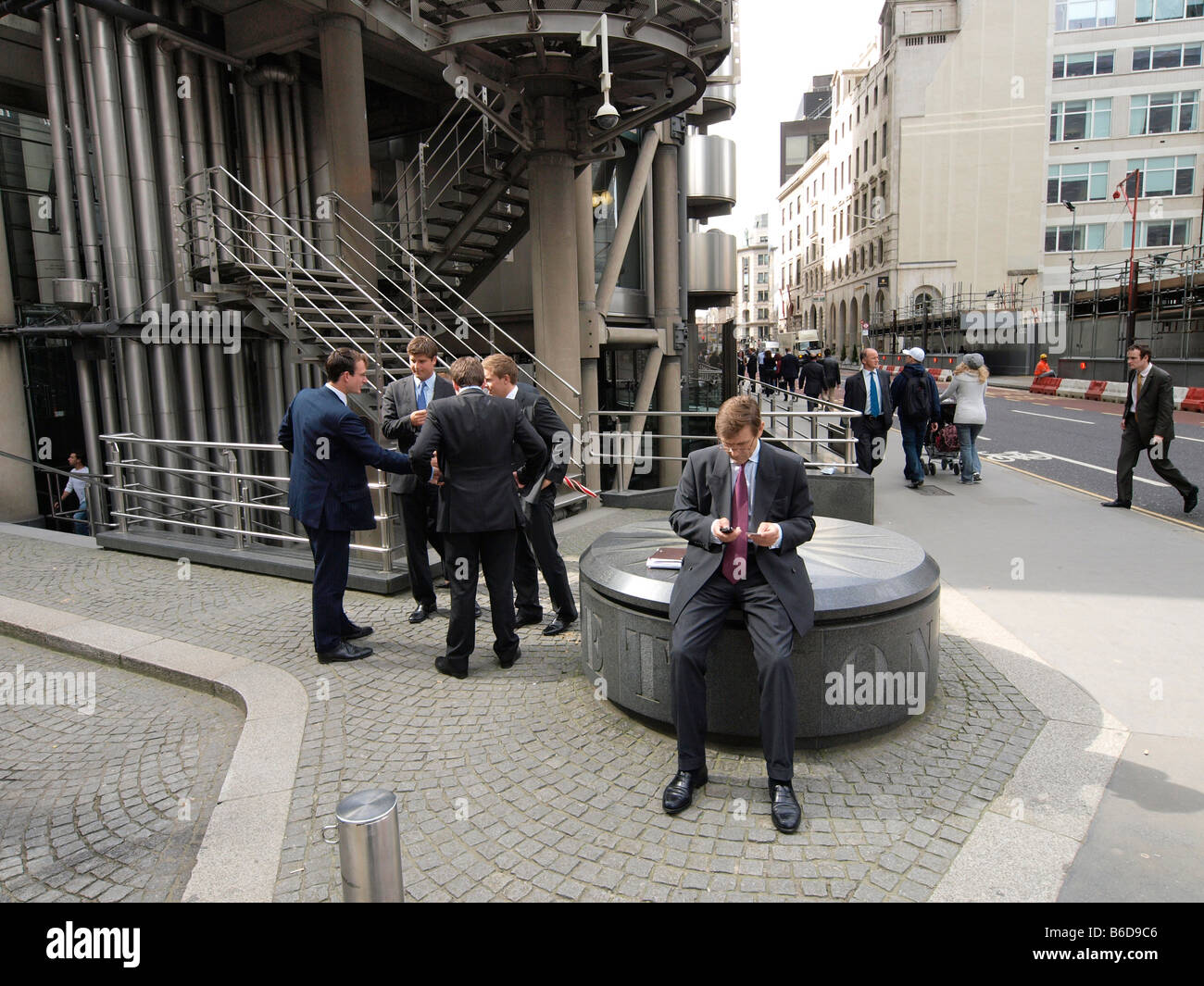 deBusinessman texting in front of the Lloyds building London city UK Stock Photo