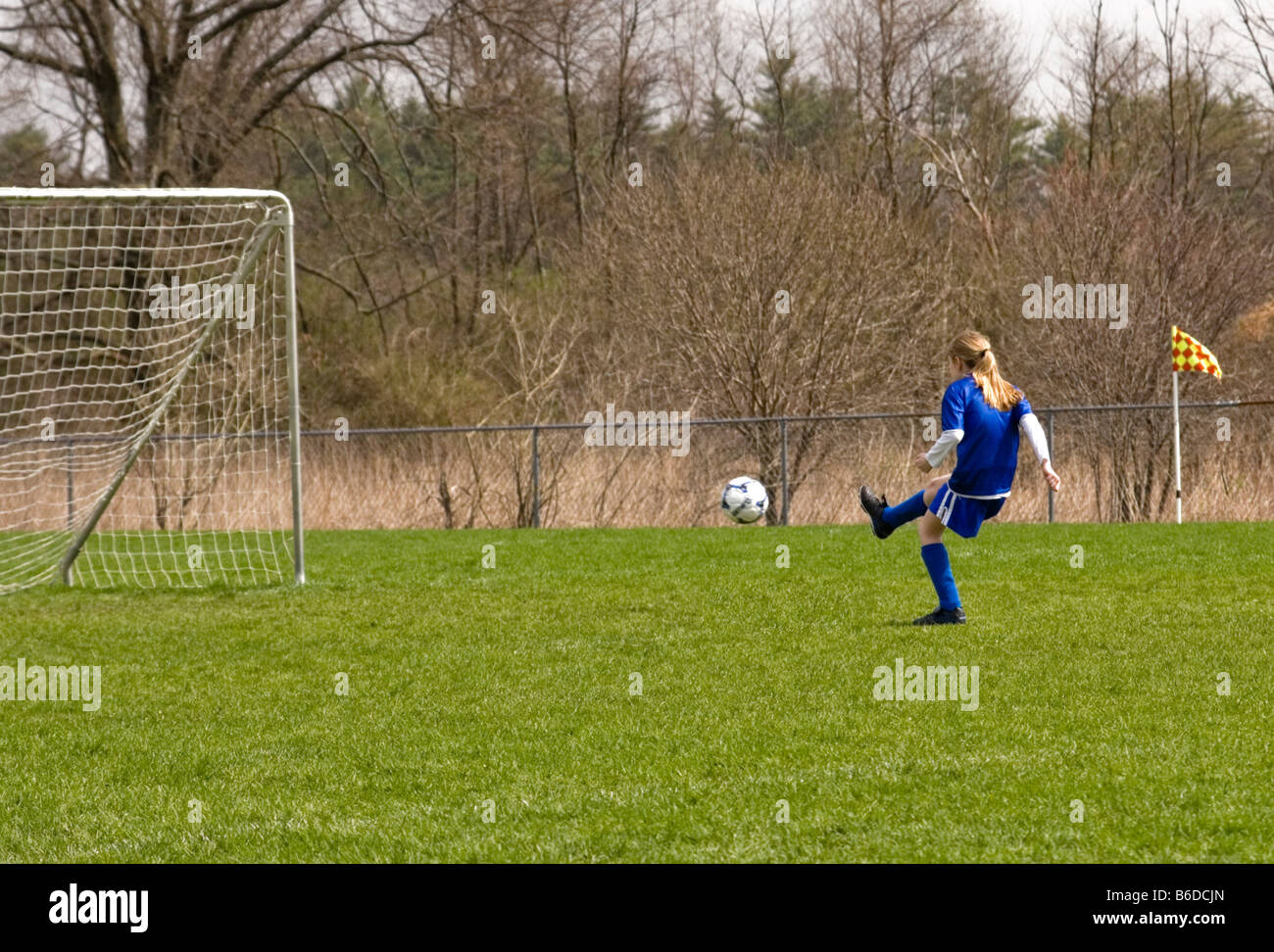 A Pretty Preteen Girl Kicks A Soccer Ball Into The Net Stock Photo Alamy