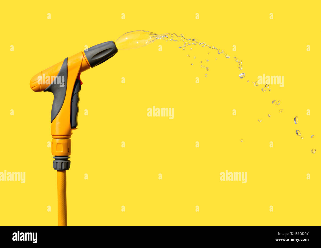 An adjustable nozzle garden hose attachment spraying a shaped water jet Stock Photo