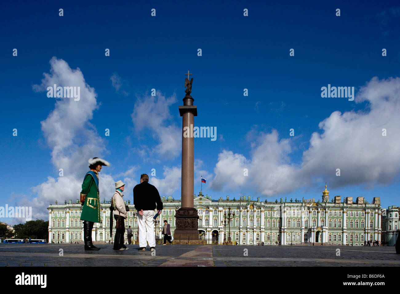 Russia, Saint Petersburg, Alexander pillar, Winter Palace and Hermitage. Visitors and man in tradiotional clothing. Stock Photo
