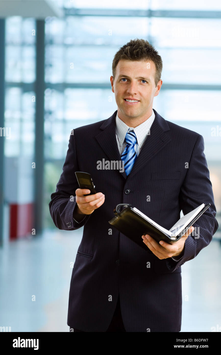 Happy businessman smiling at office lobby Stock Photo - Alamy