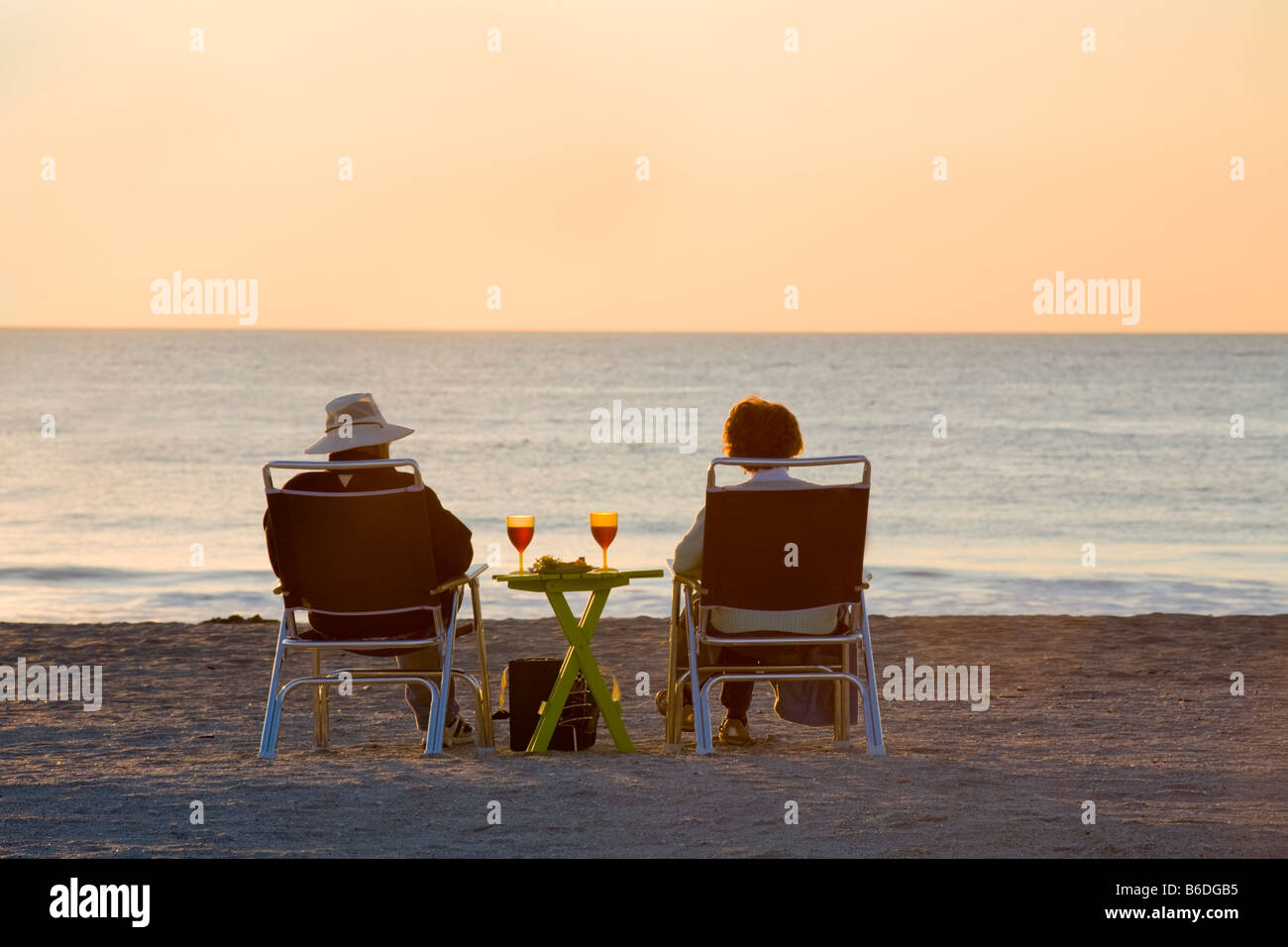 Couple drinking wine and eating snacks and watching sunset on Venice Beach on the Gulf Coast of Florida Stock Photo