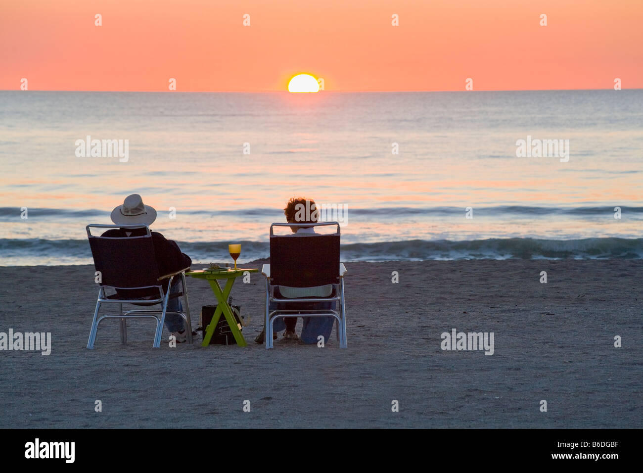 Couple drinking wine and eating snacks and watching sunset on Venice Beach on the Gulf Coast of Florida Stock Photo