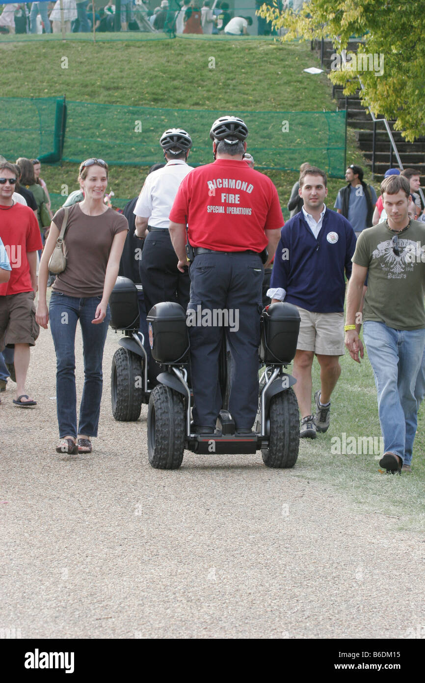 Fire and emergency services personnel utilizing a Segway personal transporter to patrol a large crowd at Richmond Folk Festival Stock Photo