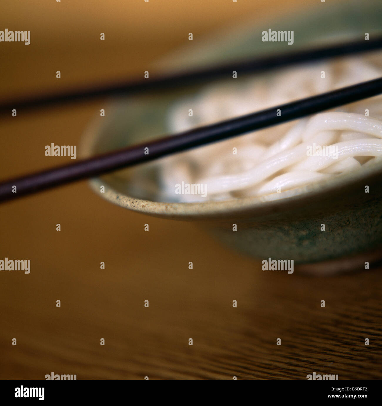 Noodles. Bowl full of noodles with a pair of chopsticks resting on top. Stock Photo