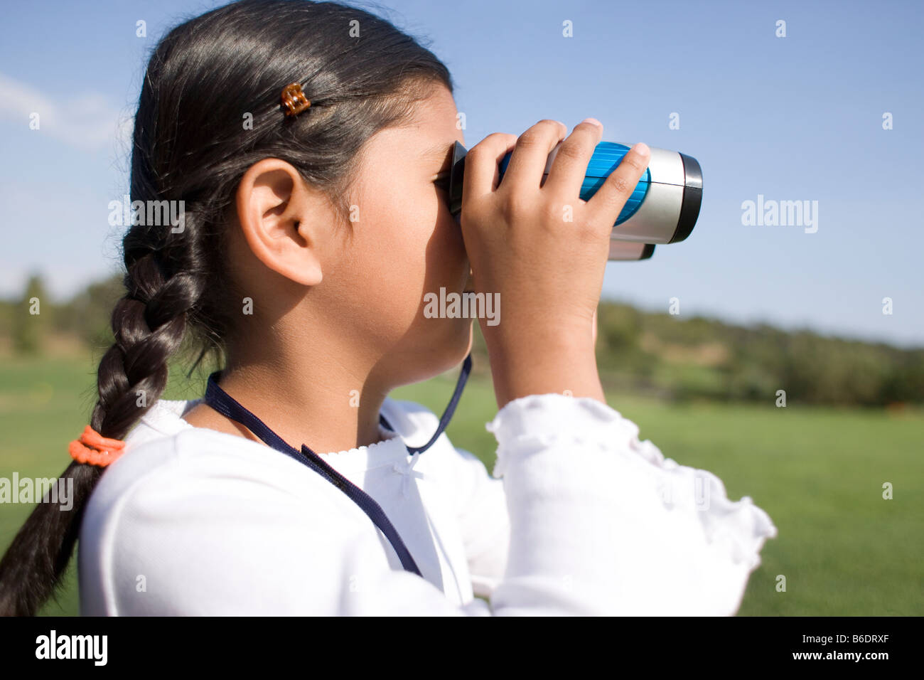 Girl using binoculars. Binoculars contain magnifying lenses that are