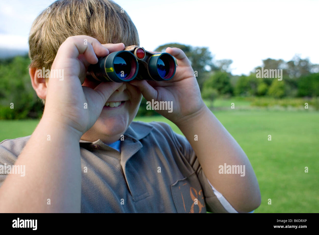 Boy using binoculars in a park Stock Photo Alamy