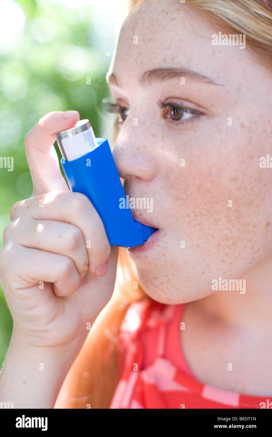 Teenage girl using an inhaler to treat an asthma attack Stock Photo Alamy