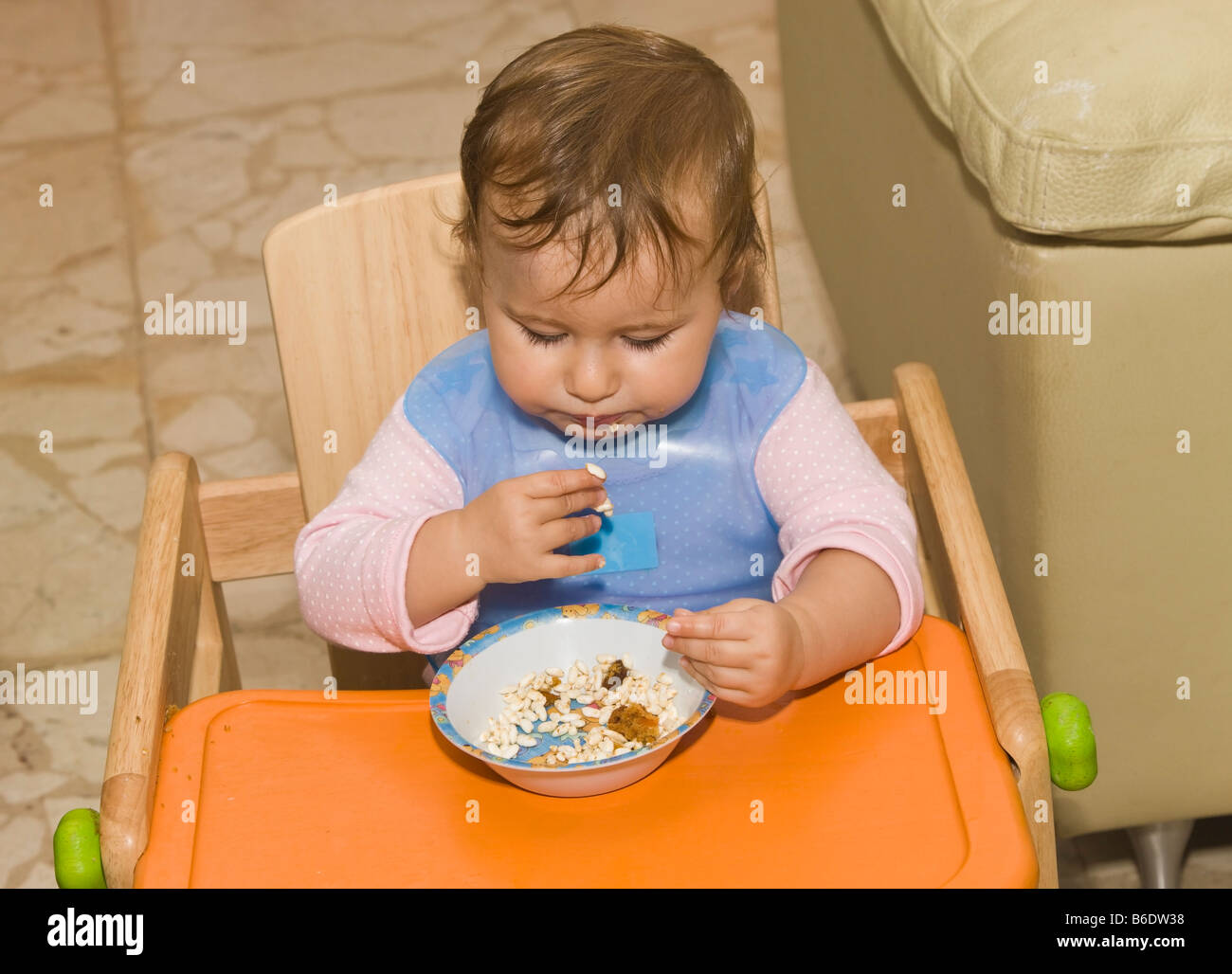 One year old toddler feeding herself Stock Photo