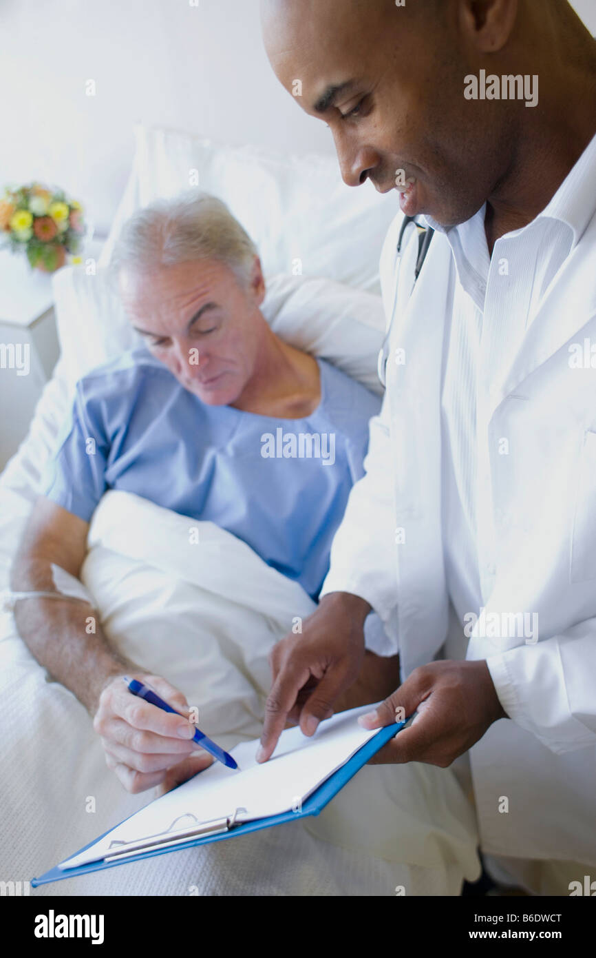 Doctor and patient. Patient signing medical forms before surgery. Stock Photo