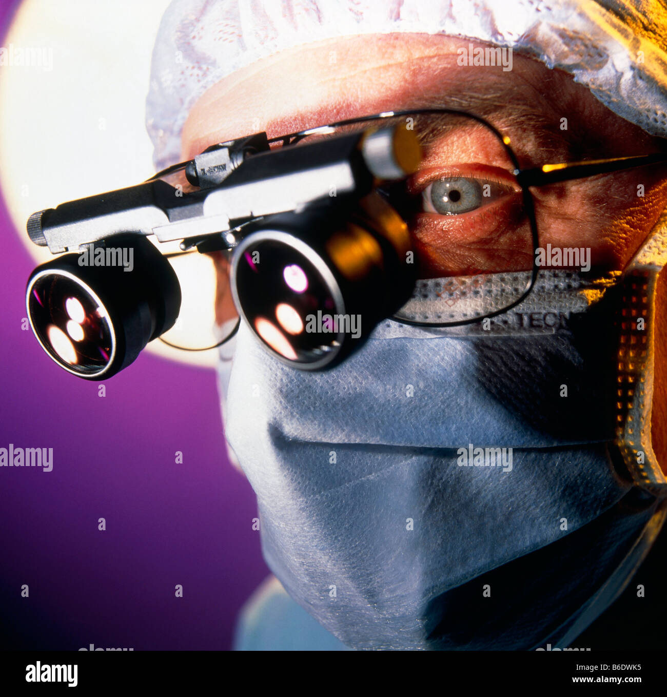 Microsurgery. Surgeon with magnifying lenses over his glasses. These