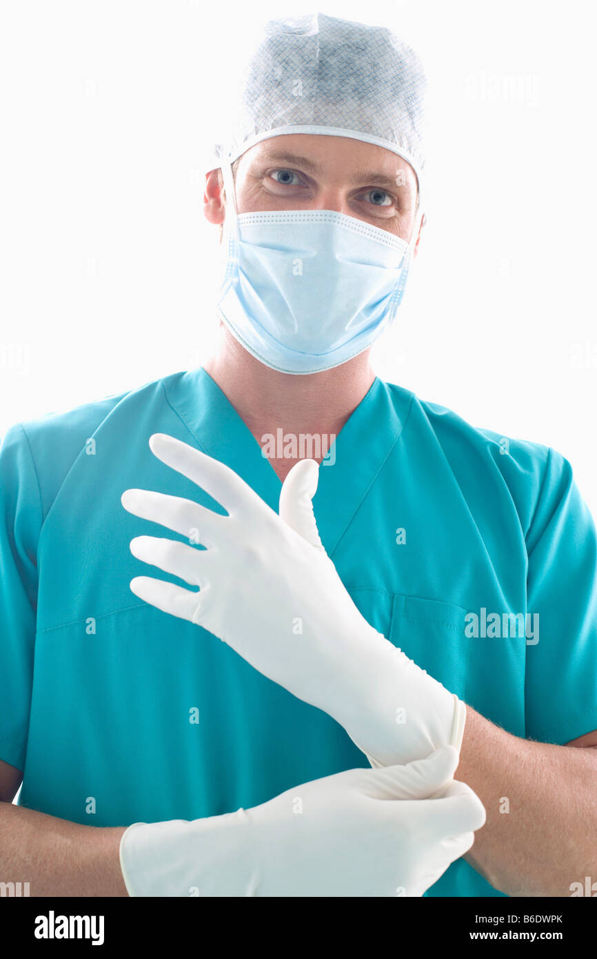 Surgeon putting on surgical gloves Stock Photo Alamy