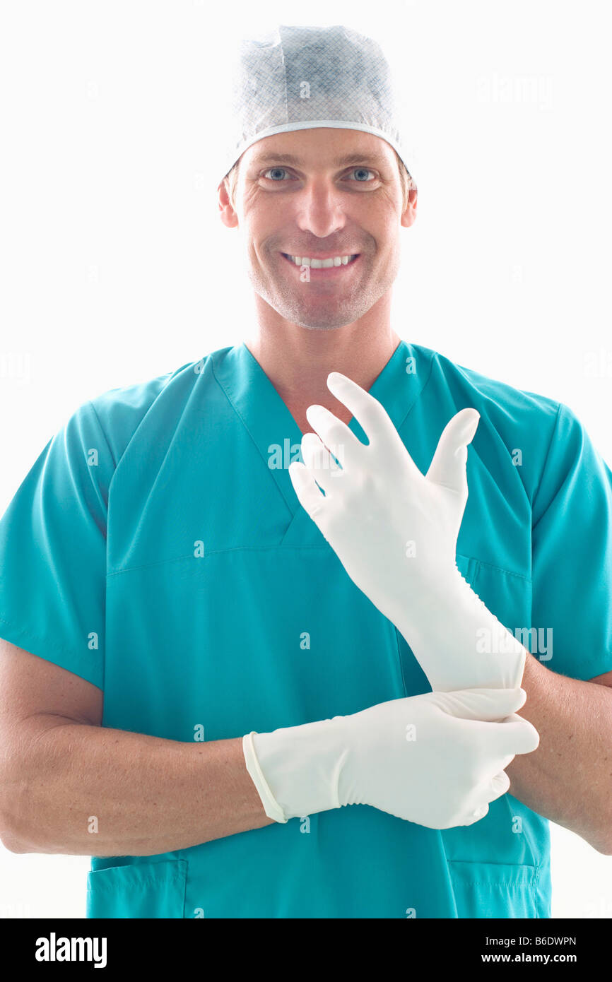 Surgeon putting on surgical gloves Stock Photo Alamy
