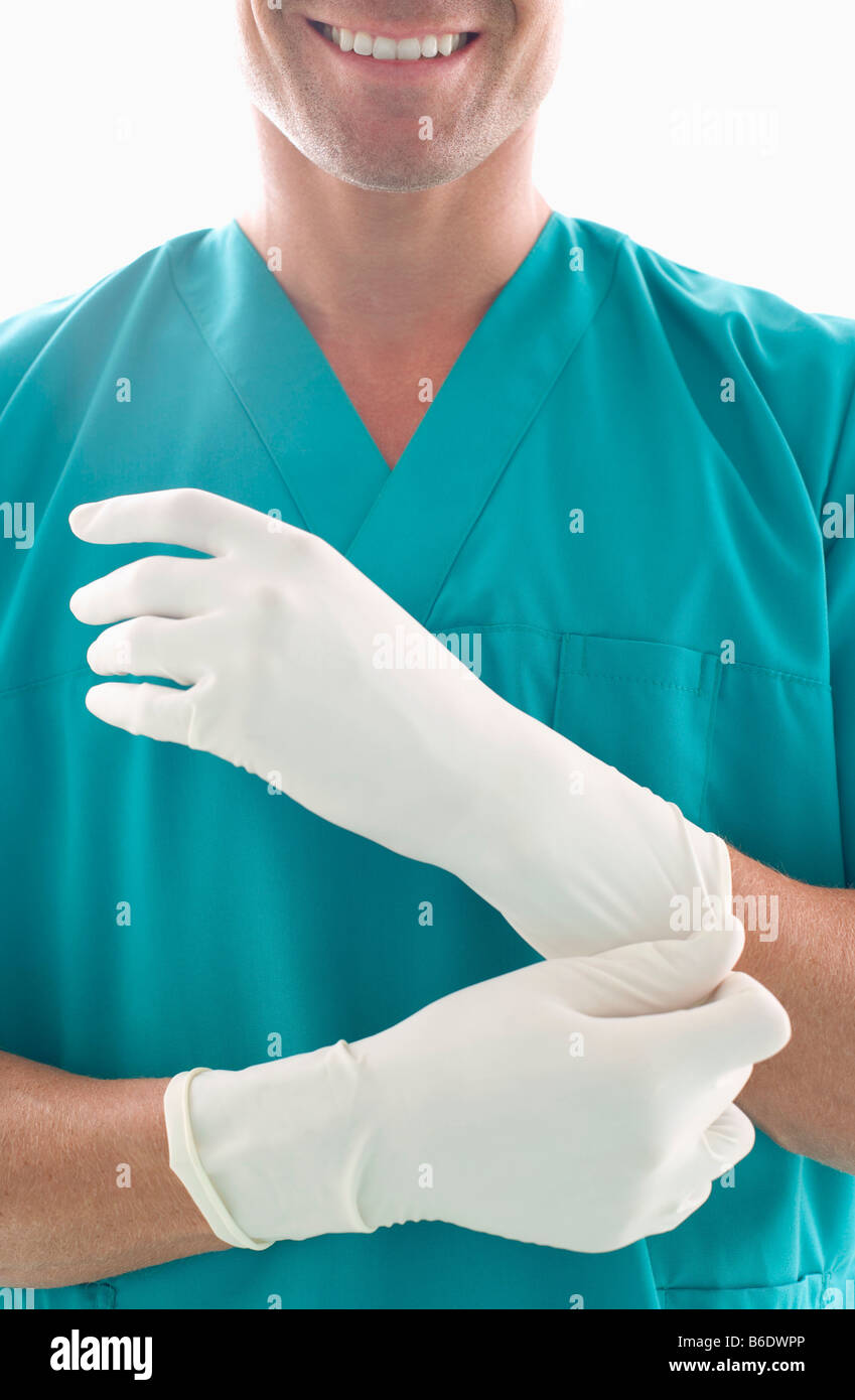 Surgeon putting on surgical gloves Stock Photo Alamy