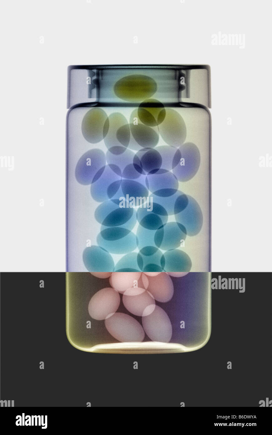 Oil capsules and in a bottle, coloured X-ray. Stock Photo