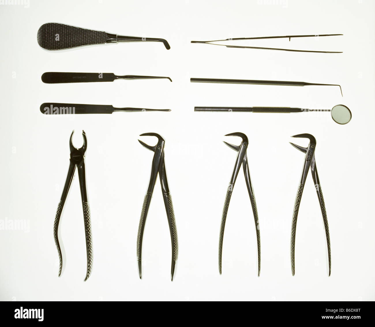 Dental equipment laid out in rows. Along bottom are four sets of pliers