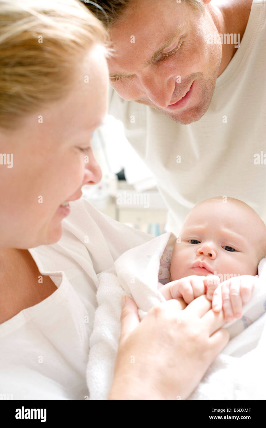 Parents and newborn baby. Mother and father in a maternity ward holding their newborn baby. Stock Photo