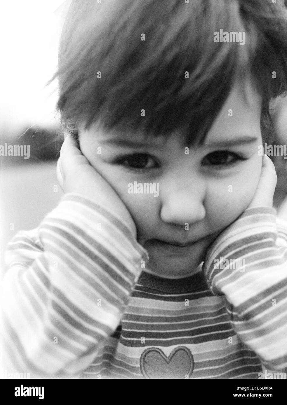 Unhappy 3-year-old girl holding her head in her hands Stock Photo - Alamy
