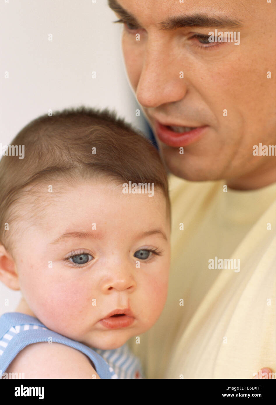 Baby boy and father. Faces of a 6 monthold baby boy and his father