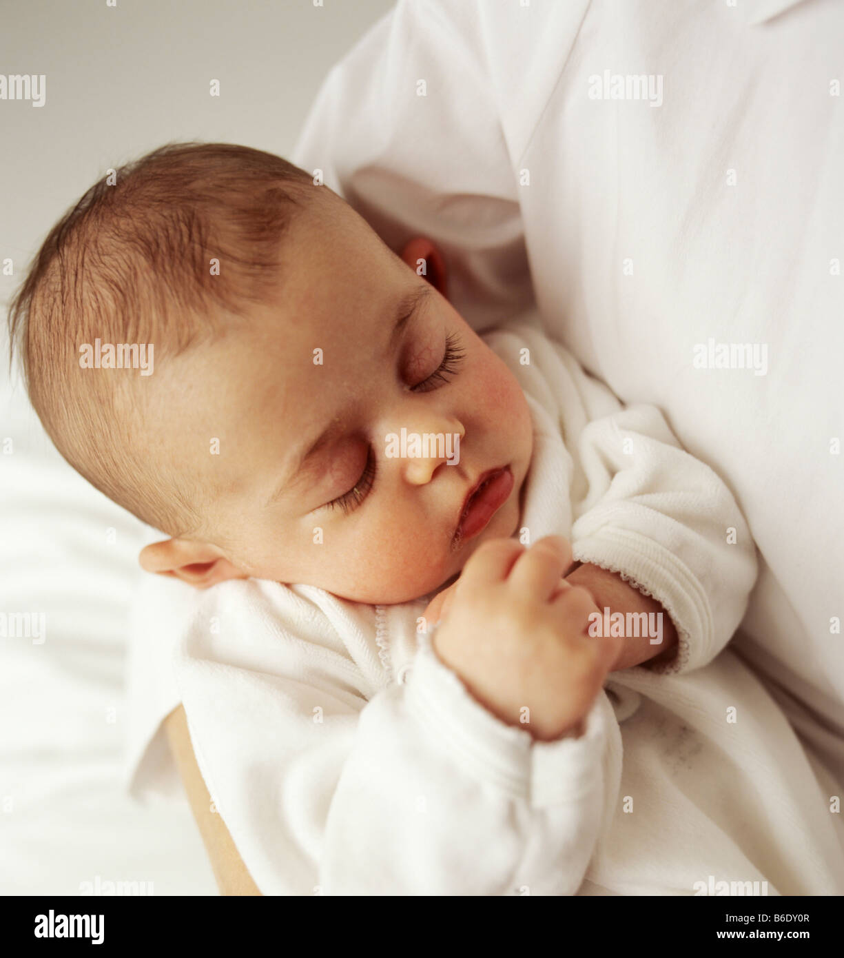Baby girl.12 week old baby girl asleep in her mother arms Stock Photo ...