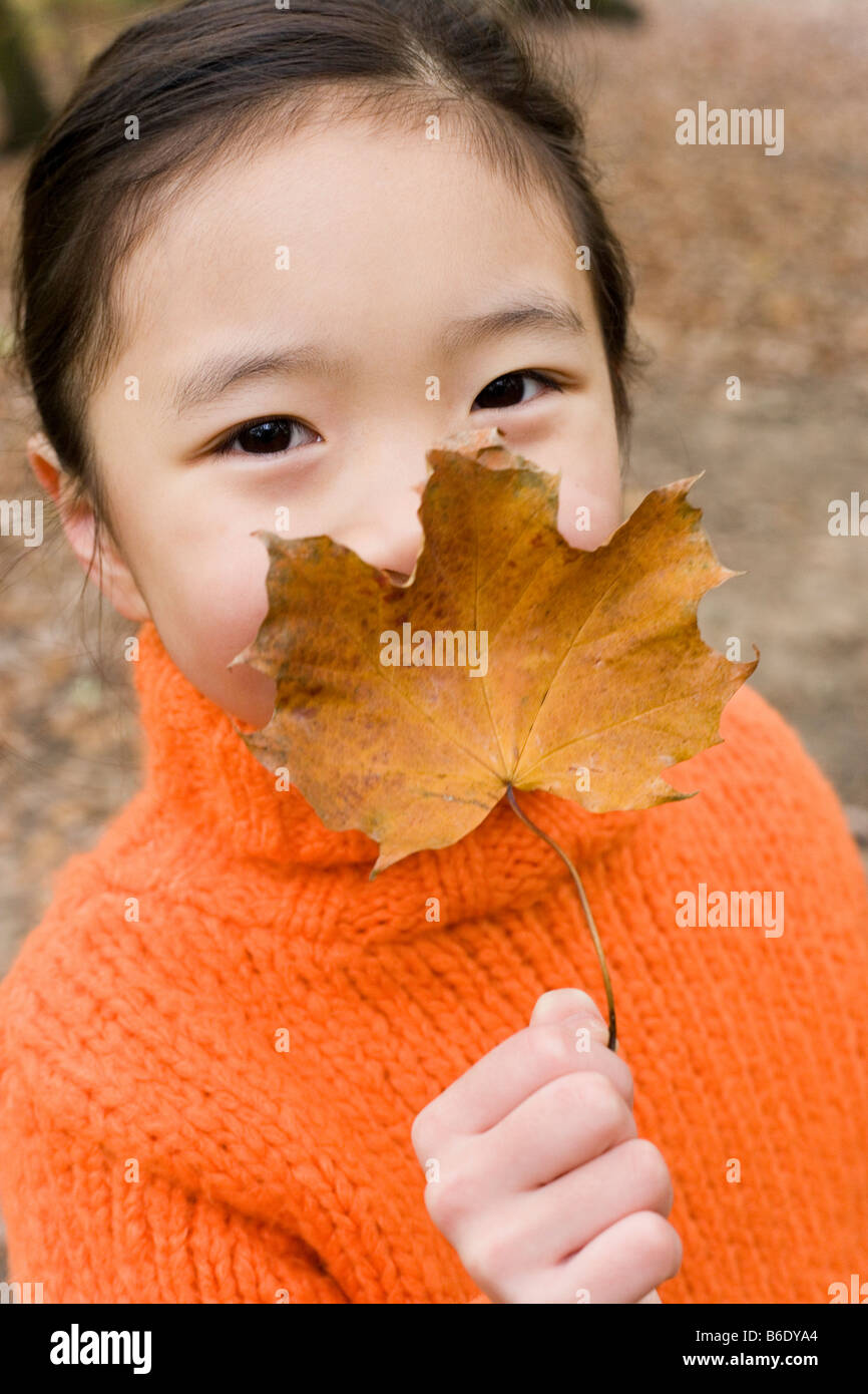 Girl holding an autumn leaf Stock Photo - Alamy