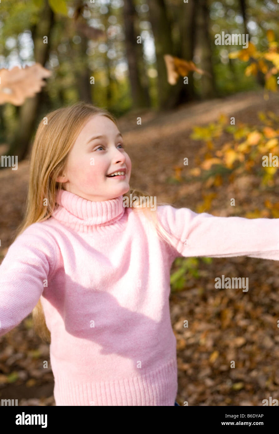 Girl playing with autumn leaves in a wood Stock Photo - Alamy