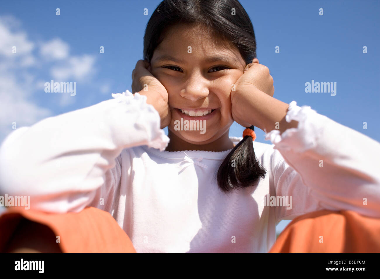 Happy girl resting her head on her hands Stock Photo - Alamy