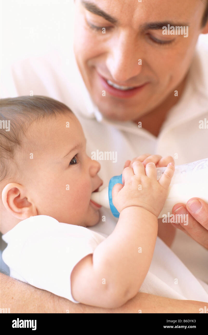 Father bottlefeeding baby. Father using a bottle to feed milk to his 5