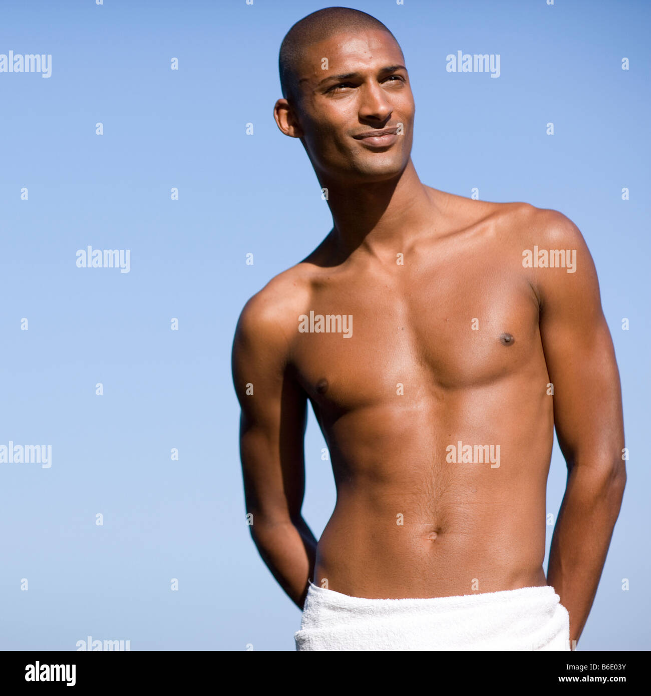 Healthy man wrapping a towel around his waist leaving his upper