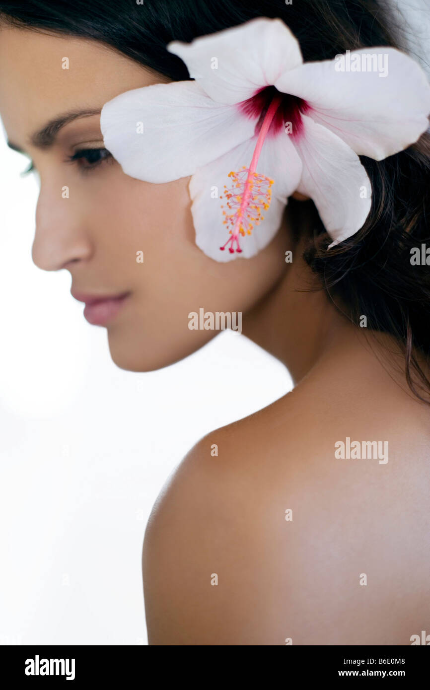 Healthy woman with a rosemallow flower in her hair. Stock Photo