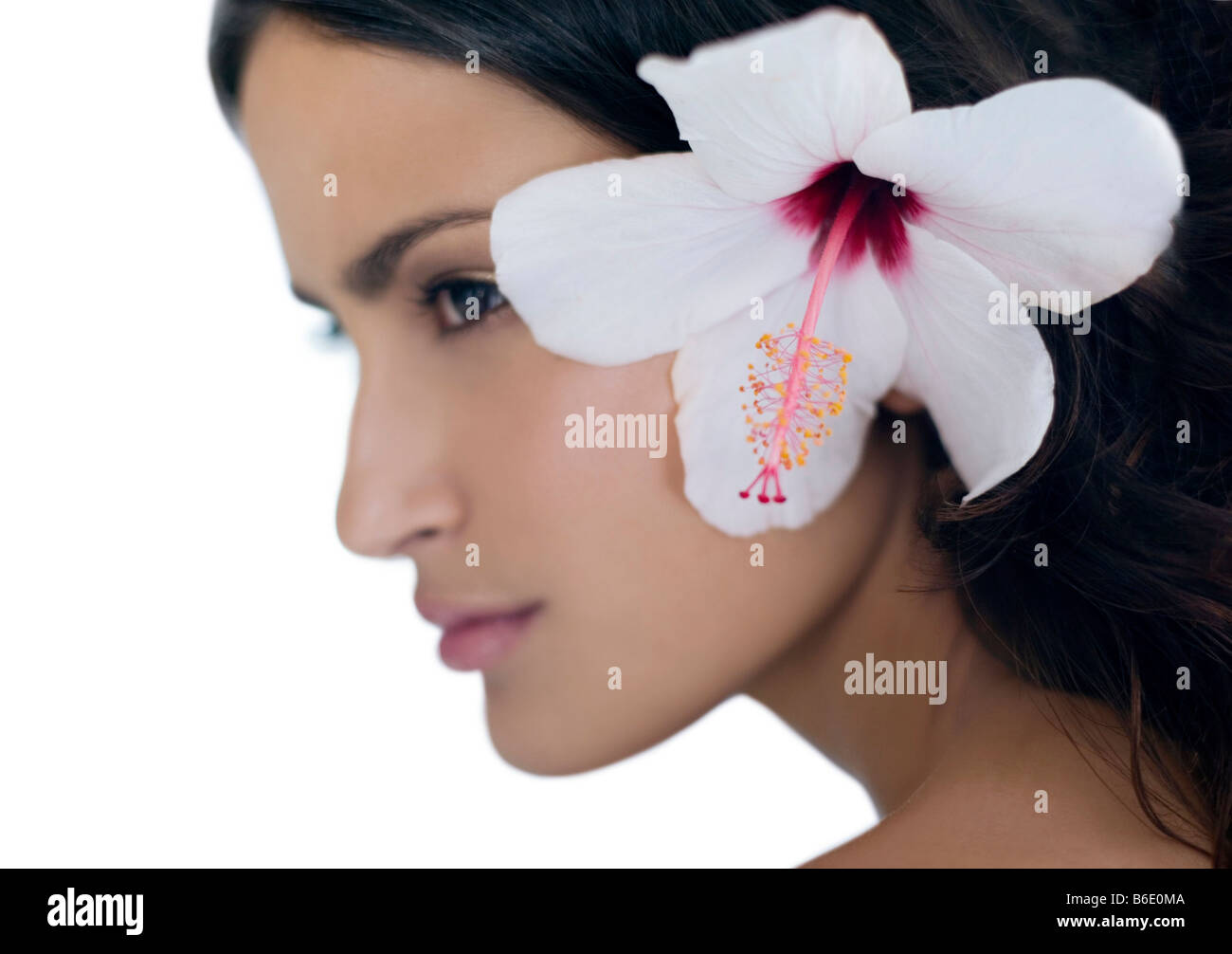 Healthy woman with a rosemallow flower in her hair. Stock Photo