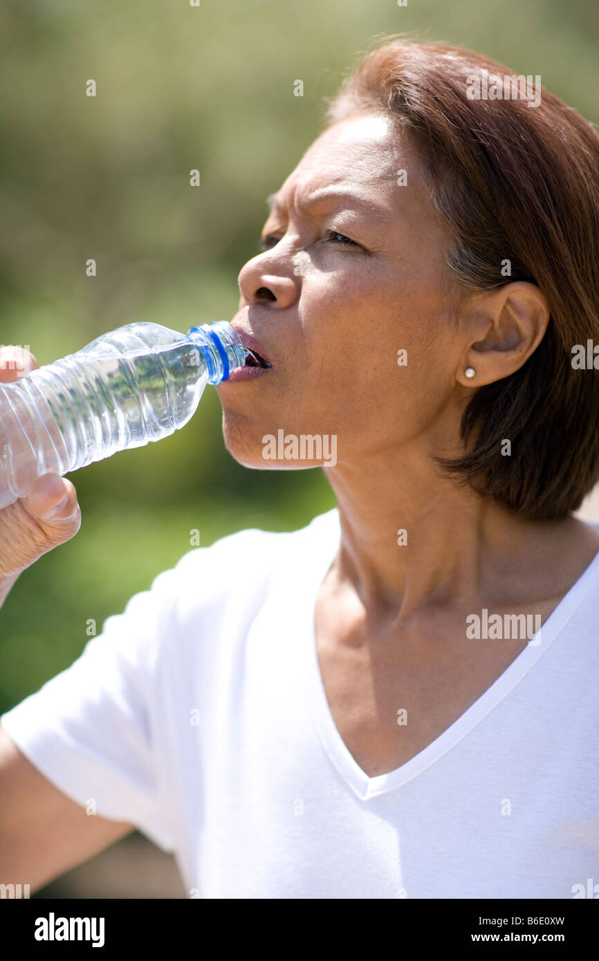Woman drinking duringexercise. Water is lost by sweating whenexercising it is important to drink plenty of water Stock Photo