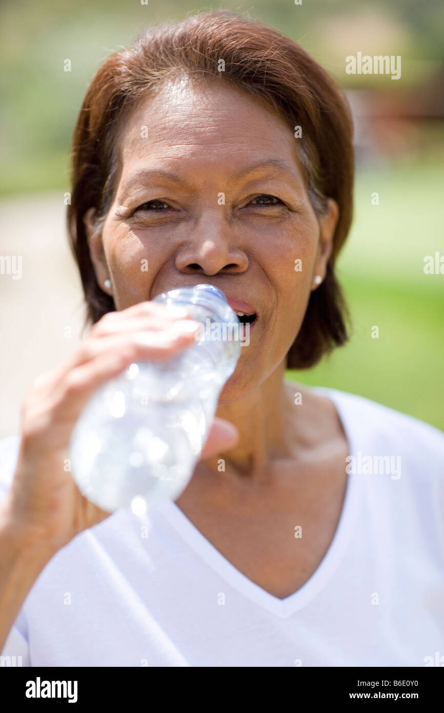 Woman drinking duringexercise. Water is lost by sweating whenexercising it is important to drink plenty of water Stock Photo