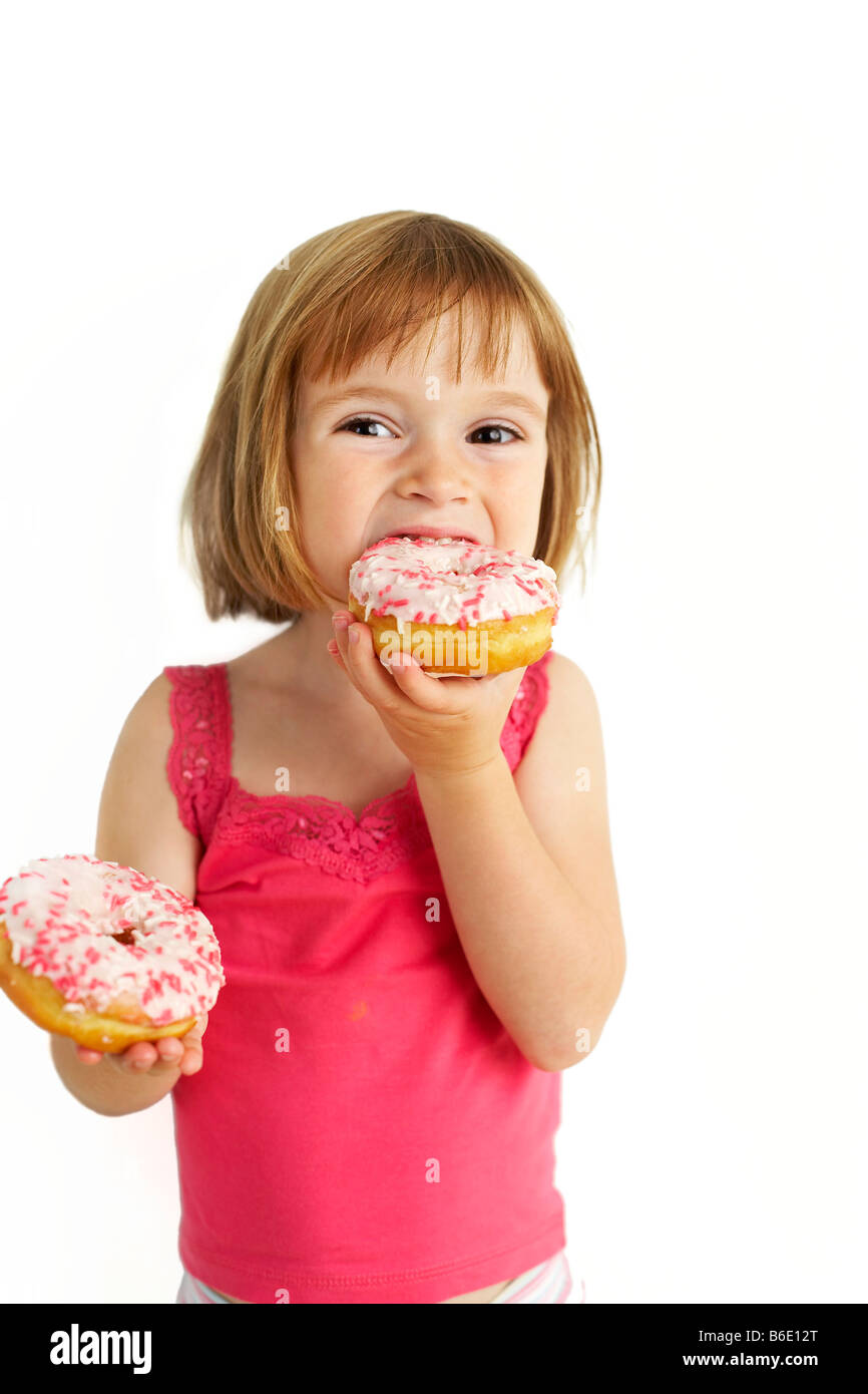 Girl eating doughnuts. She is four years old Stock Photo Alamy