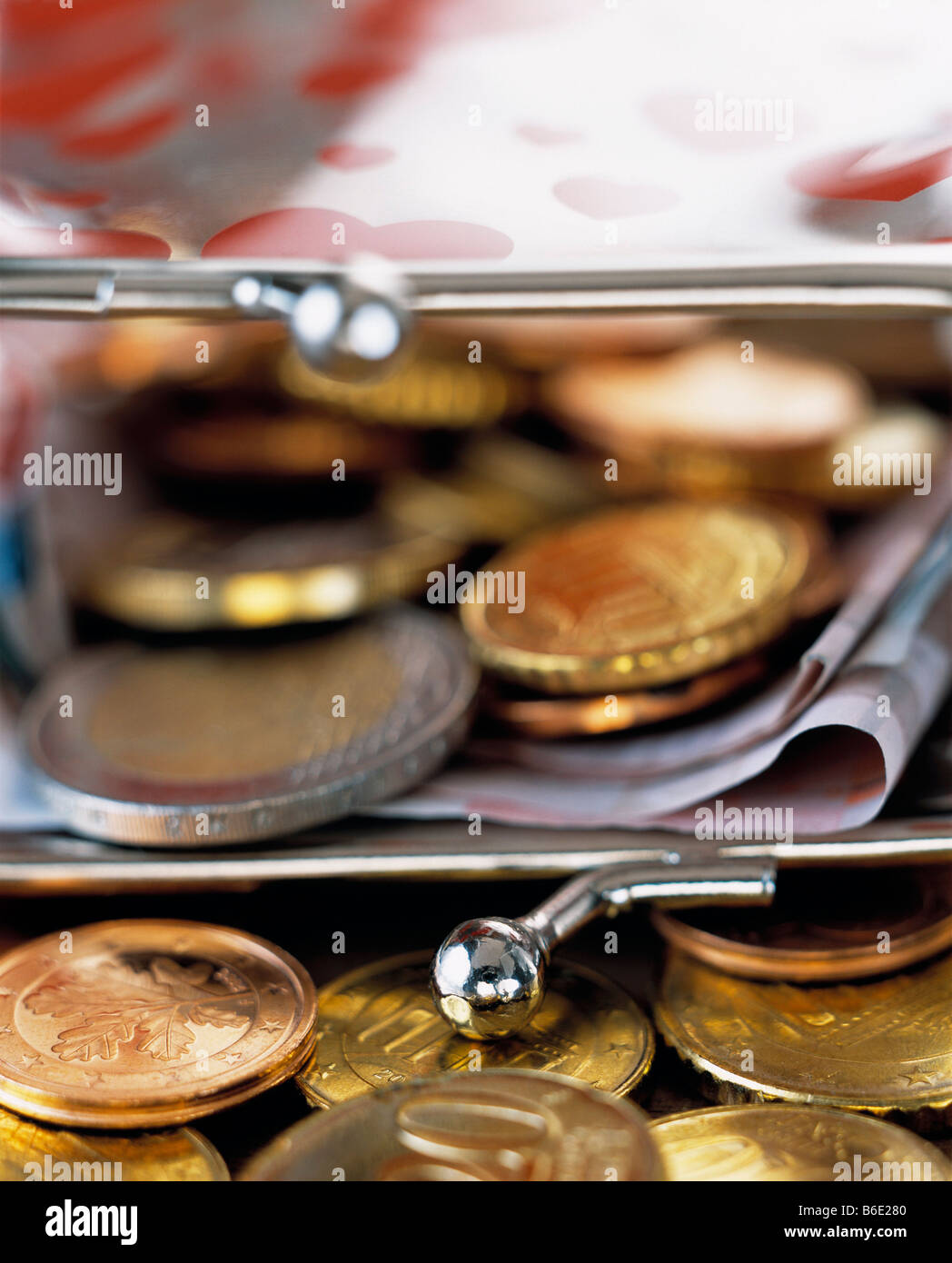 Euro coins spilling out of a purse containing folded Euro notes. Stock Photo