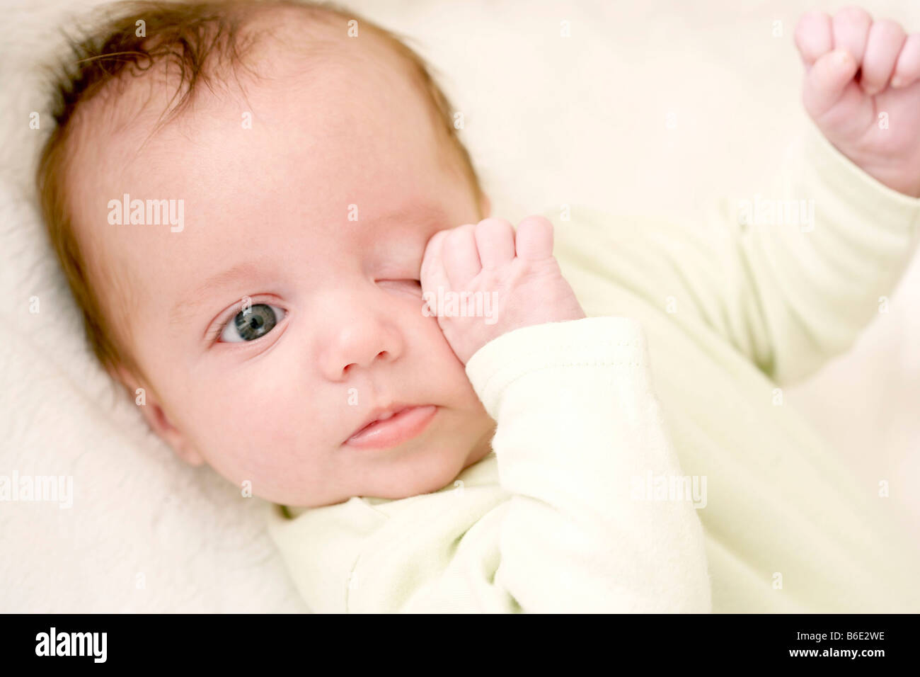Tired baby girl rubbing her eye Stock Photo Alamy