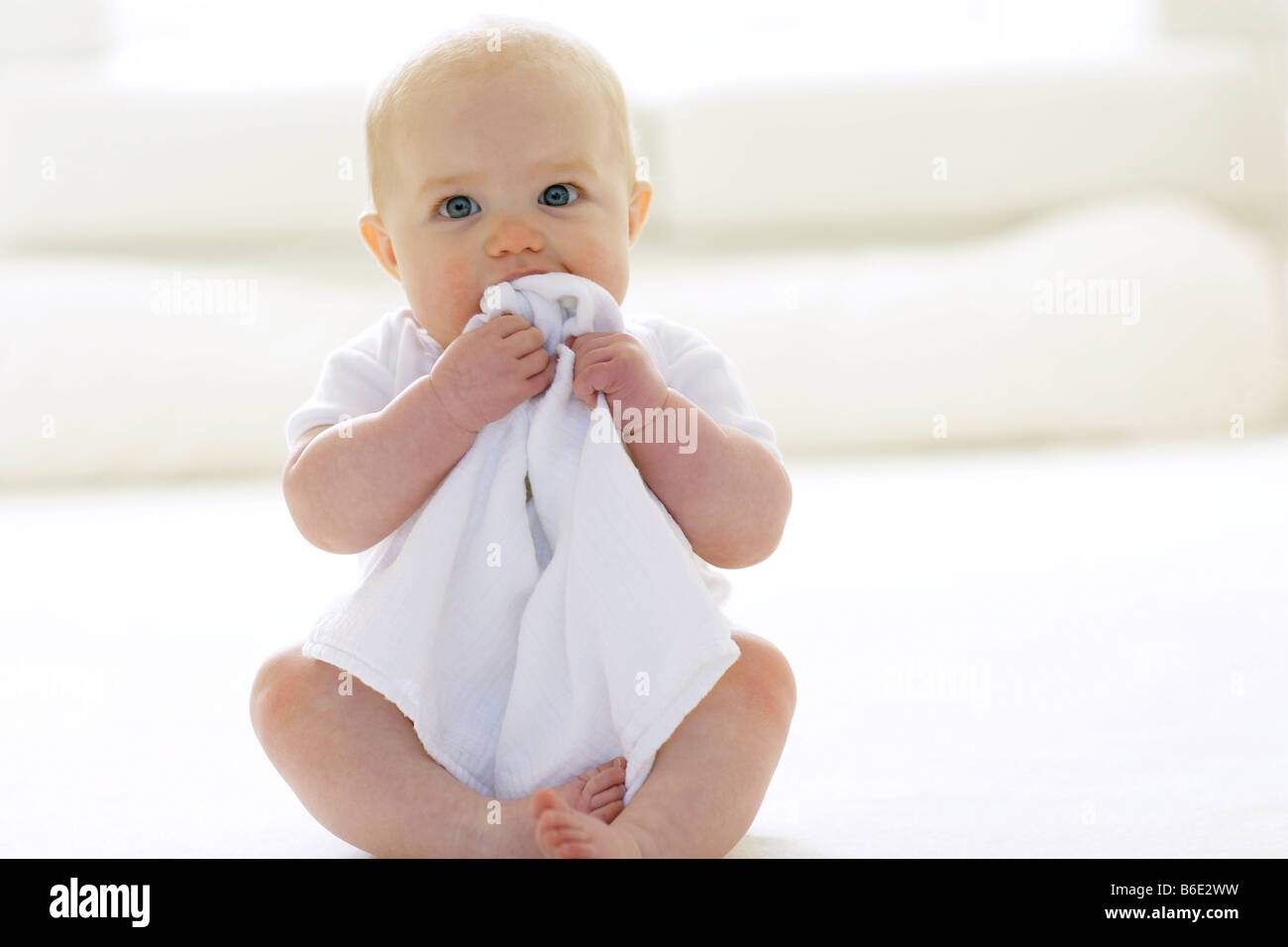 Baby girl chewing a blanket Stock Photo Alamy