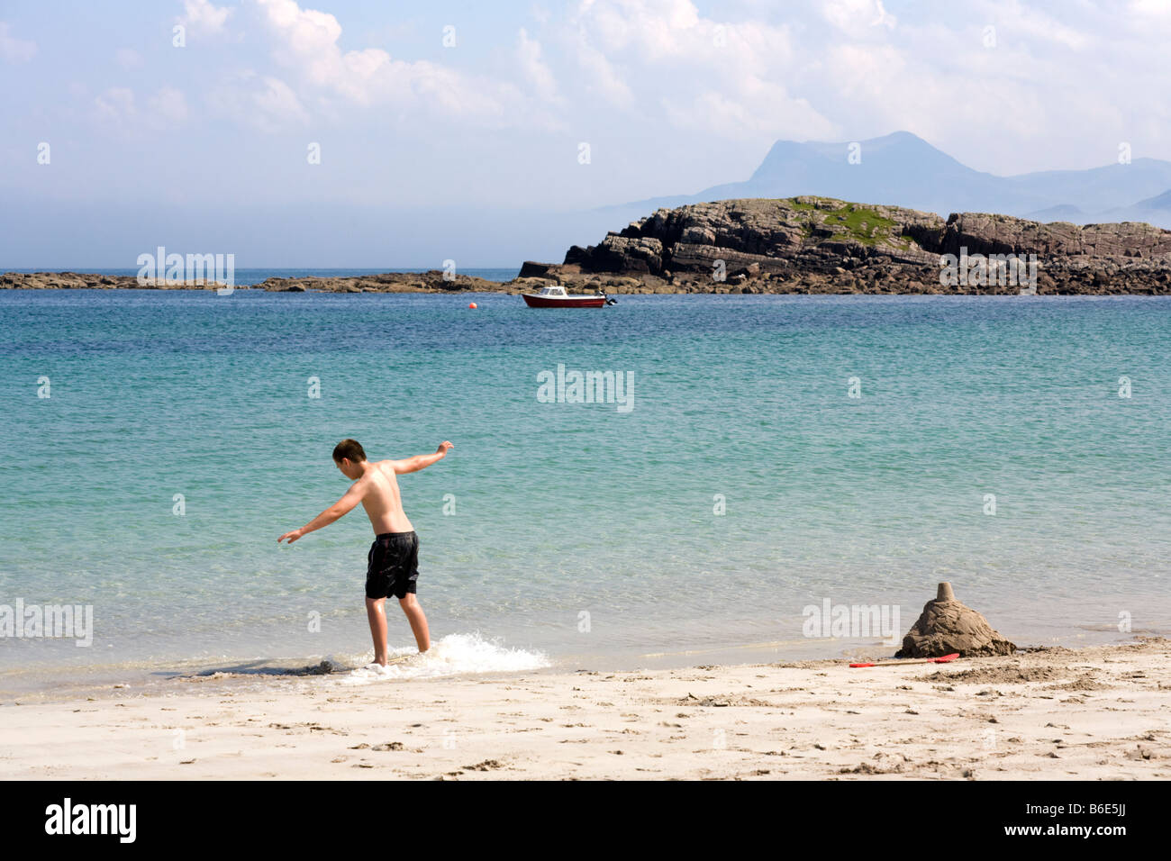 An eleven year old boy skimboarding on the beach at Mellon Udrigle, Wester Ross, Highland, Scotland Stock Photo