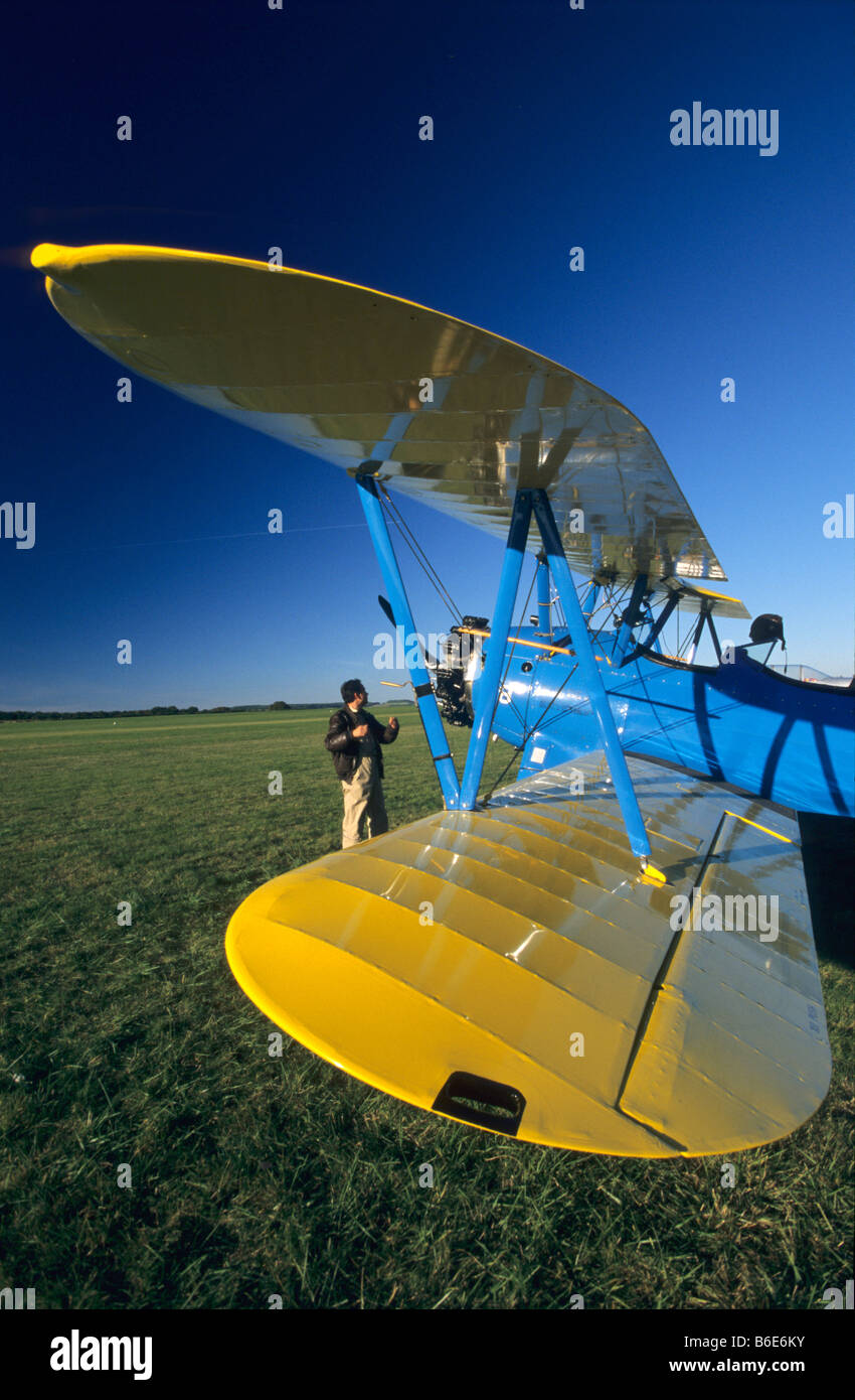 Old american trainer biplane Boeing PT-17 Kaydet / Stearman model 75- pilot pre checking his aircraft Stock Photo