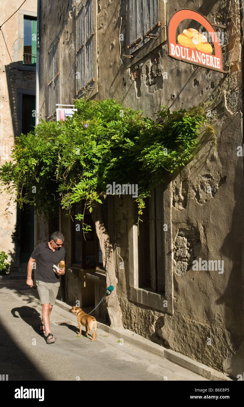 A man walks past a Boulangerie in Lagrasse South of France Stock Photo