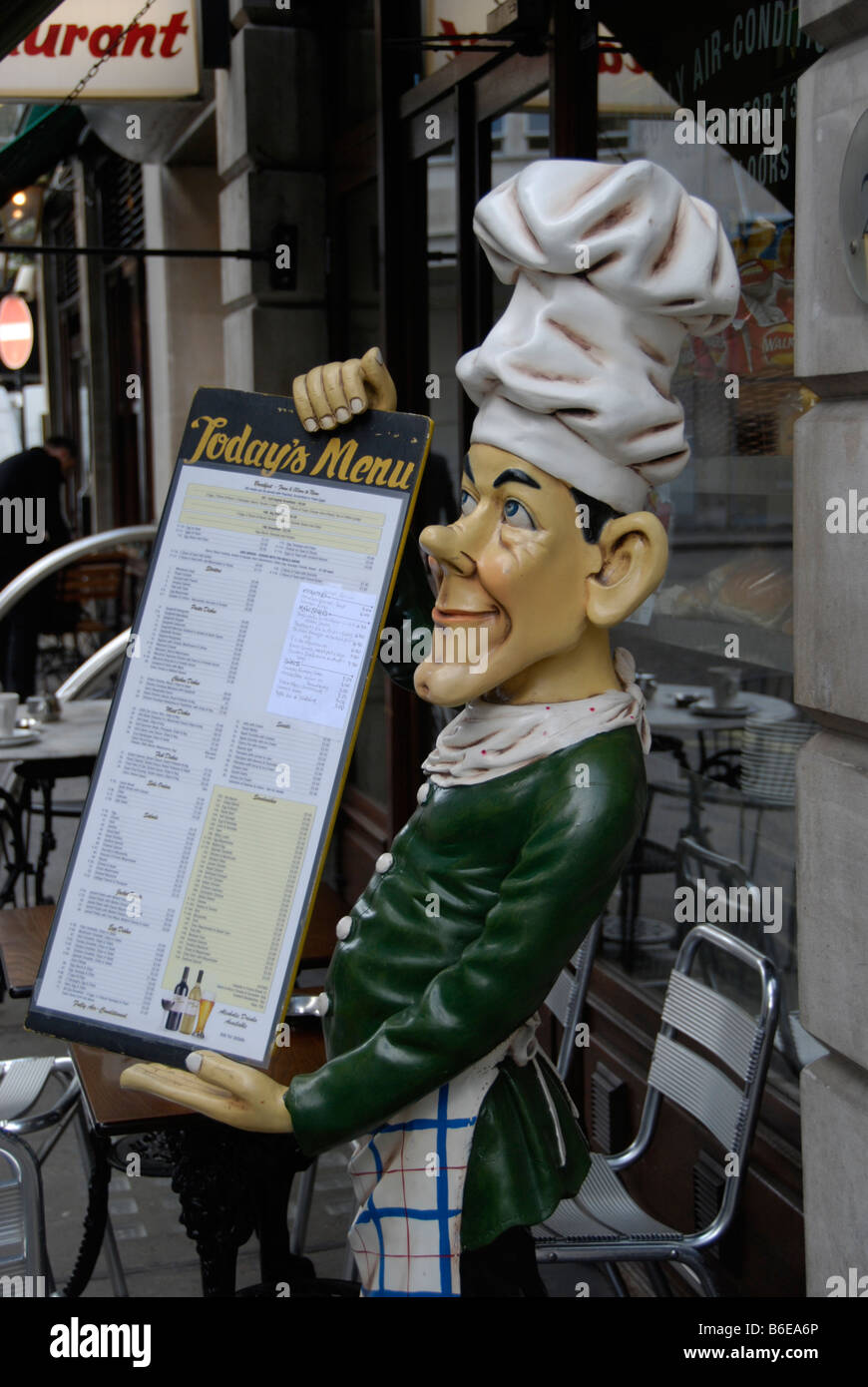 Ceramic model of a chef holding a menu outside London restaurant cafe Stock Photo