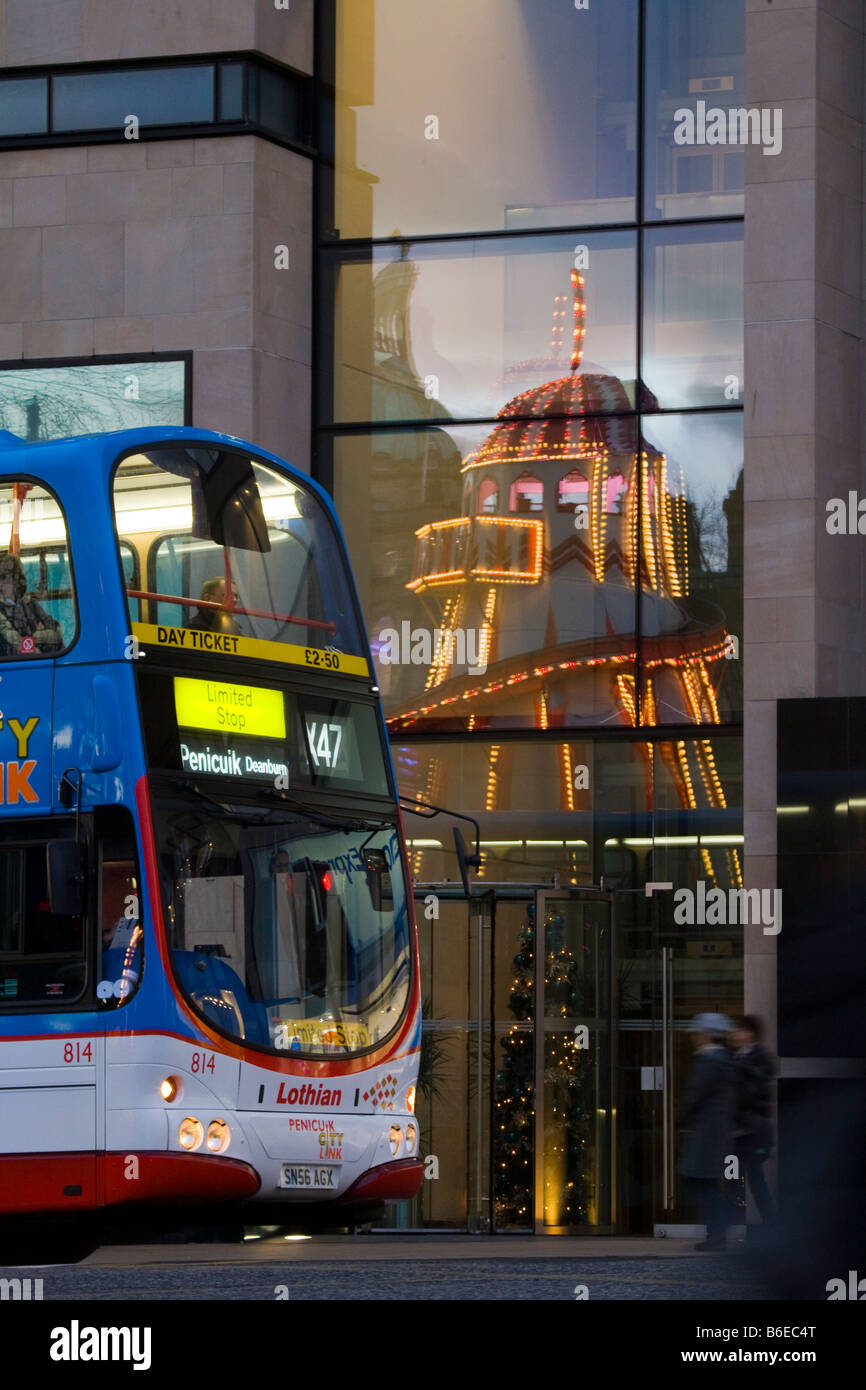 Public transport, window reflections; Christmas, amusement rides, events and attractions in Princess Street, Edinburgh, Scotland, UK Stock Photo