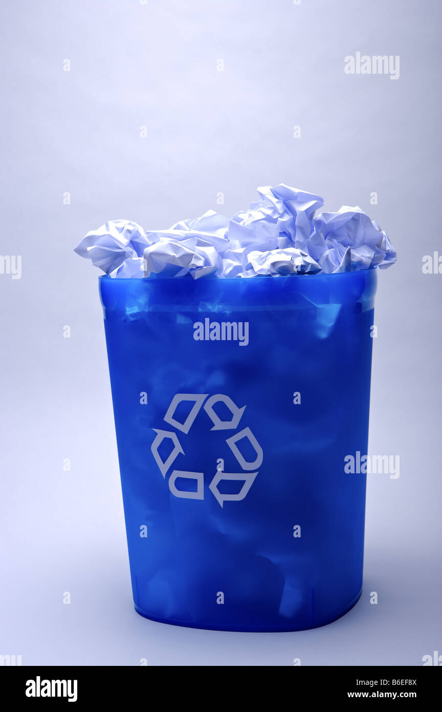 Blue recycling bin filled with crumpled paper Stock Photo Alamy
