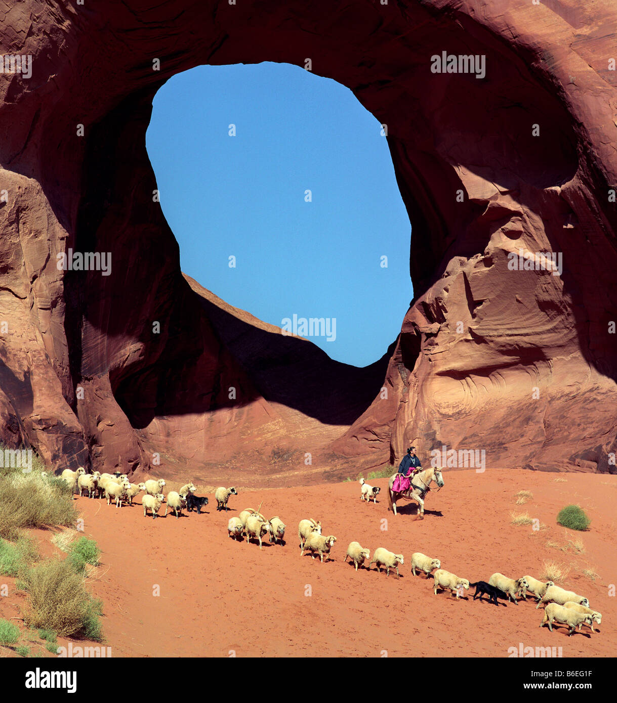 Navajo Woman herding sheep at the Ear of the Wind in Monument Valley Stock Photo