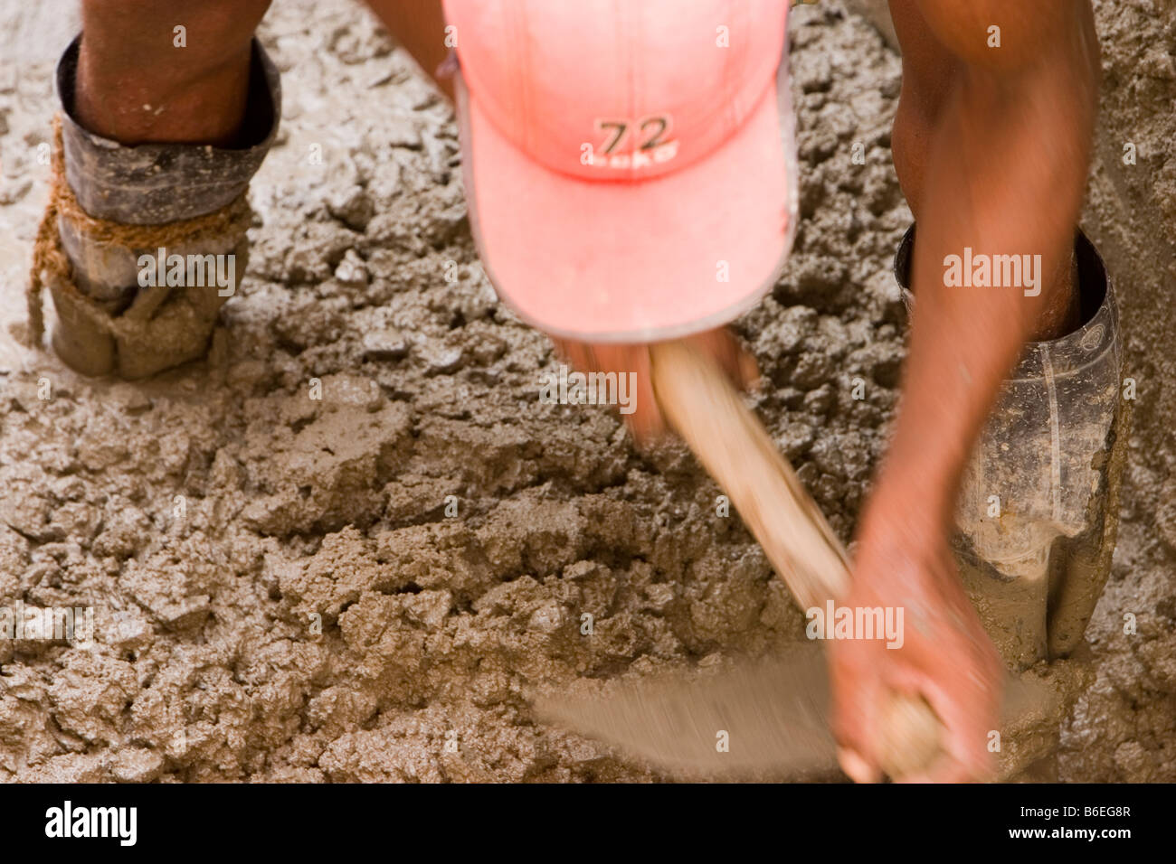 Mason mixing concrete at a building construction site in Chennai, Tamil