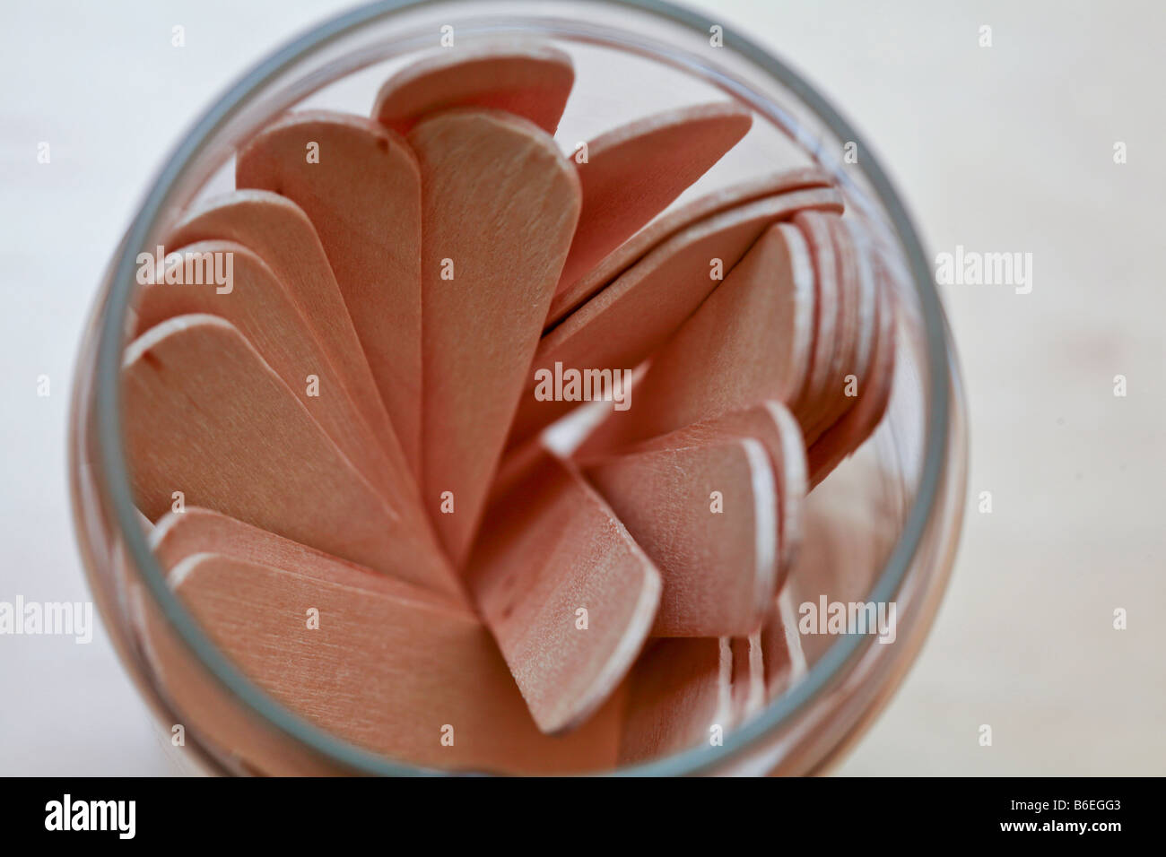 overhead view of tongue depressors in a pattern in a glass container